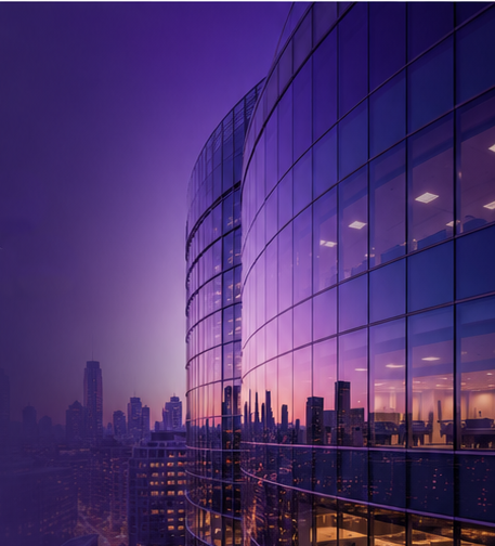 Modern glass office tower reflecting a purple city sunset